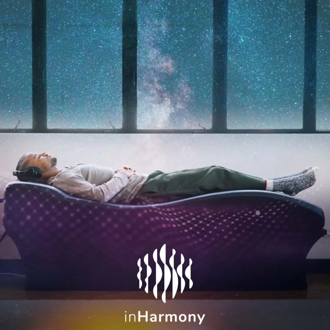 Person relaxing on Sound Lounge therapy bed with ambient lighting